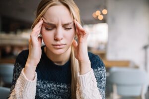 woman with hands on head experiencing opiate withdrawal symptoms