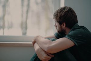 man looking out window during cocaine withdrawal