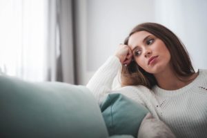 woman looking out window during alcohol withdrawal at home