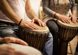 people plaing drums in music therapy program