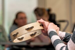 tambourine and woman discussing what is music therapy