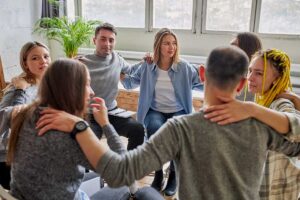 people in a circle with arms around each other consider the benefits of smart recovery program