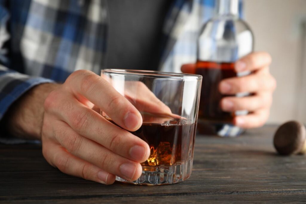 a man pours himself another drink causing him to reach a dangerous blood alcohol level